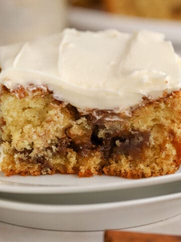 Slice of cinnamon roll cake on a white plate.