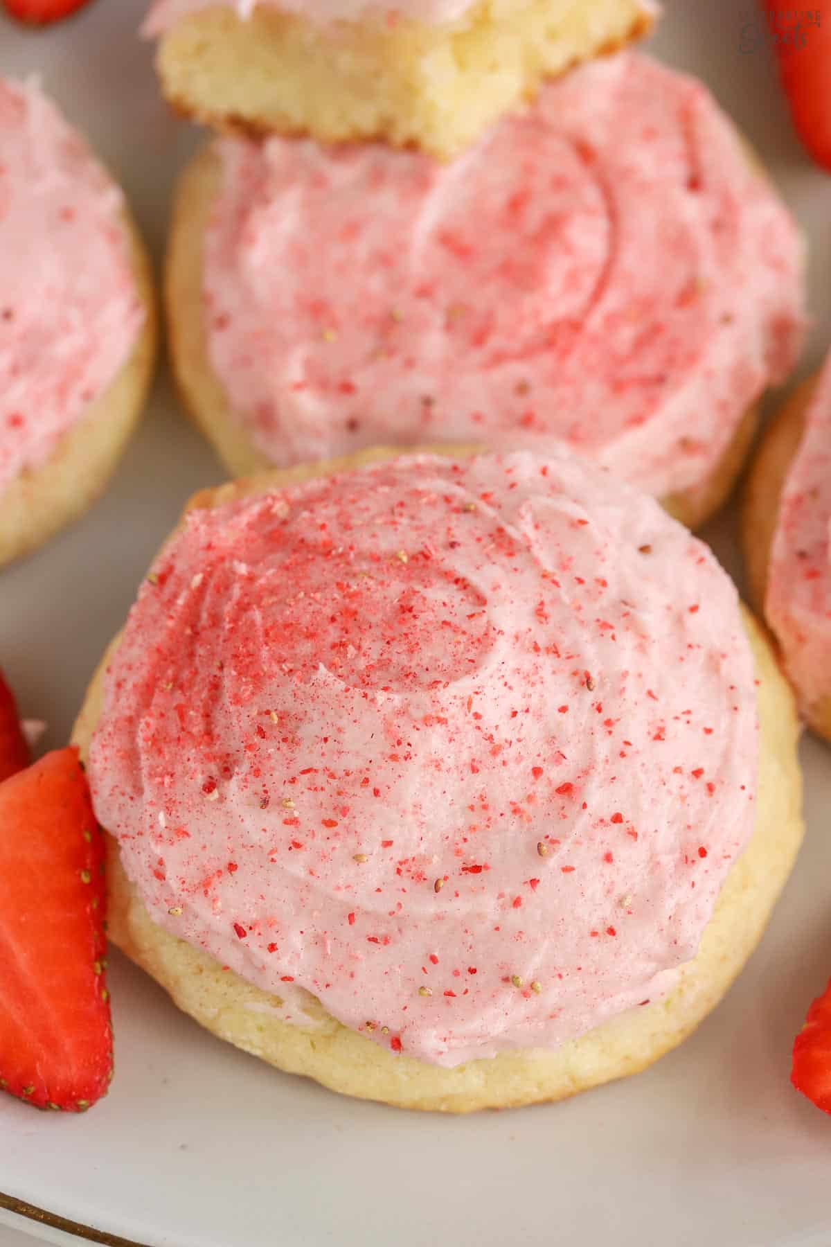 Closeup of sugar cookie topped with pink frosting.