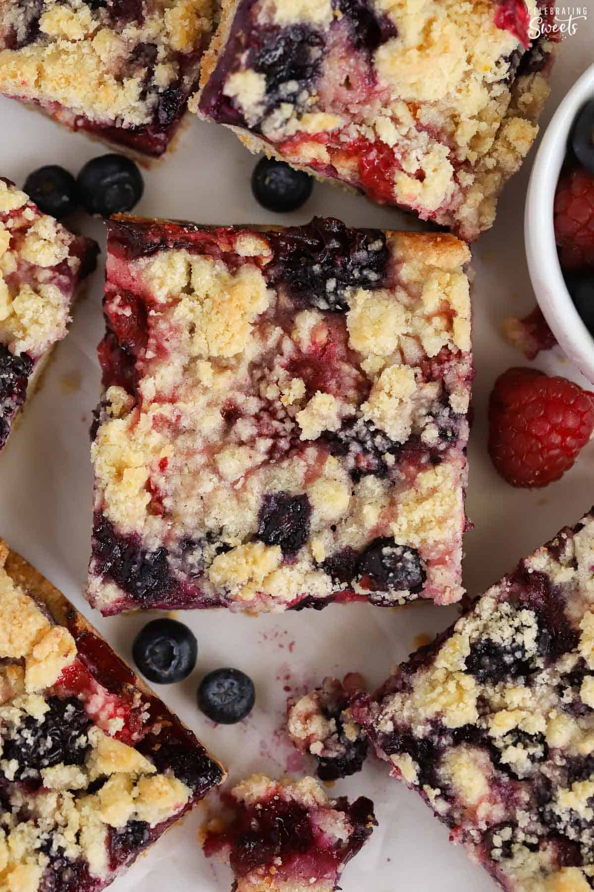 Closeup of berry crumble bars on parchment paper.