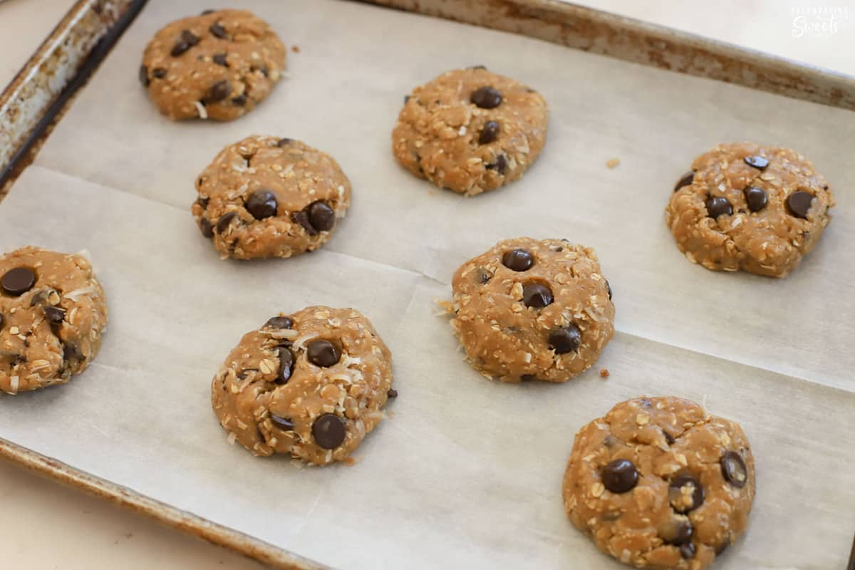 Cookie dough on a parchment paper lined baking sheet.