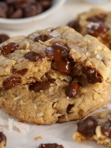 Oatmeal cookie broken in half filled with chocolate chips.