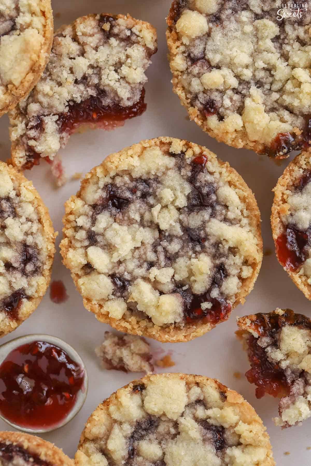 Closeup of a raspberry crumble cookie next to a spoonful of jam.