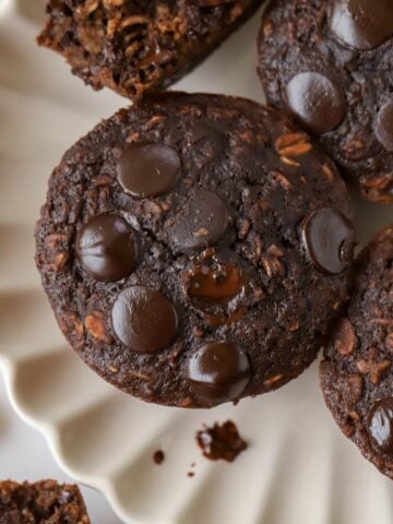 Chocolate oatmeal cups on a white scalloped plate.