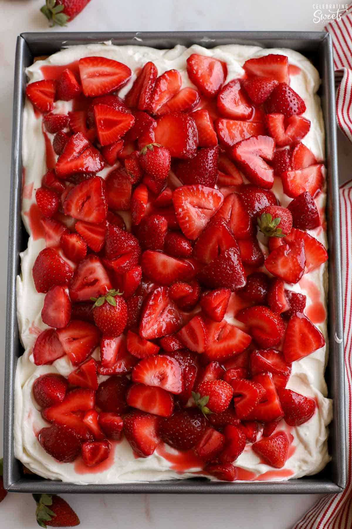 Strawberry sheet cake in a metal baking pan.