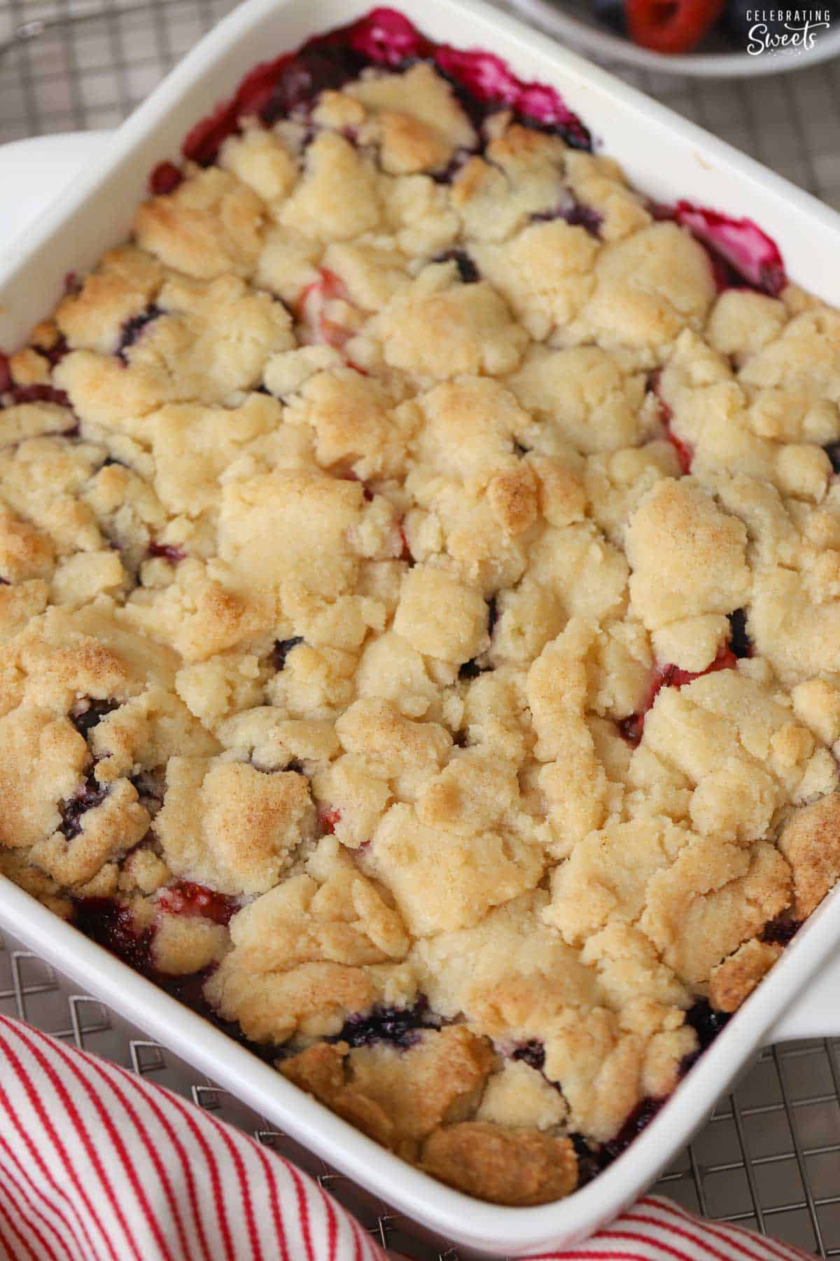 Closeup of berry cobbler in a white baking dish.