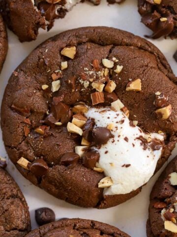 Chocolate cookie topped with marshmallows and nuts.