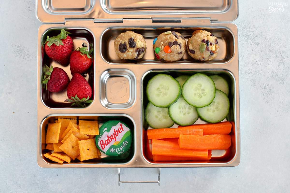 Lunchbox filled with fruit, veggies, cheese, energy bites, and crackers.