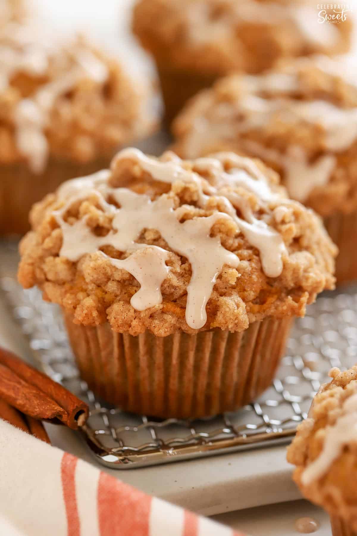 Closeup of a pumpkin muffin on a wire rack topped with icing.