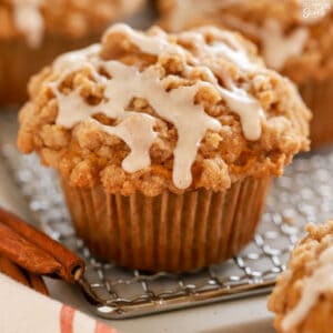 Closeup of a pumpkin muffin on a wire rack topped with icing.