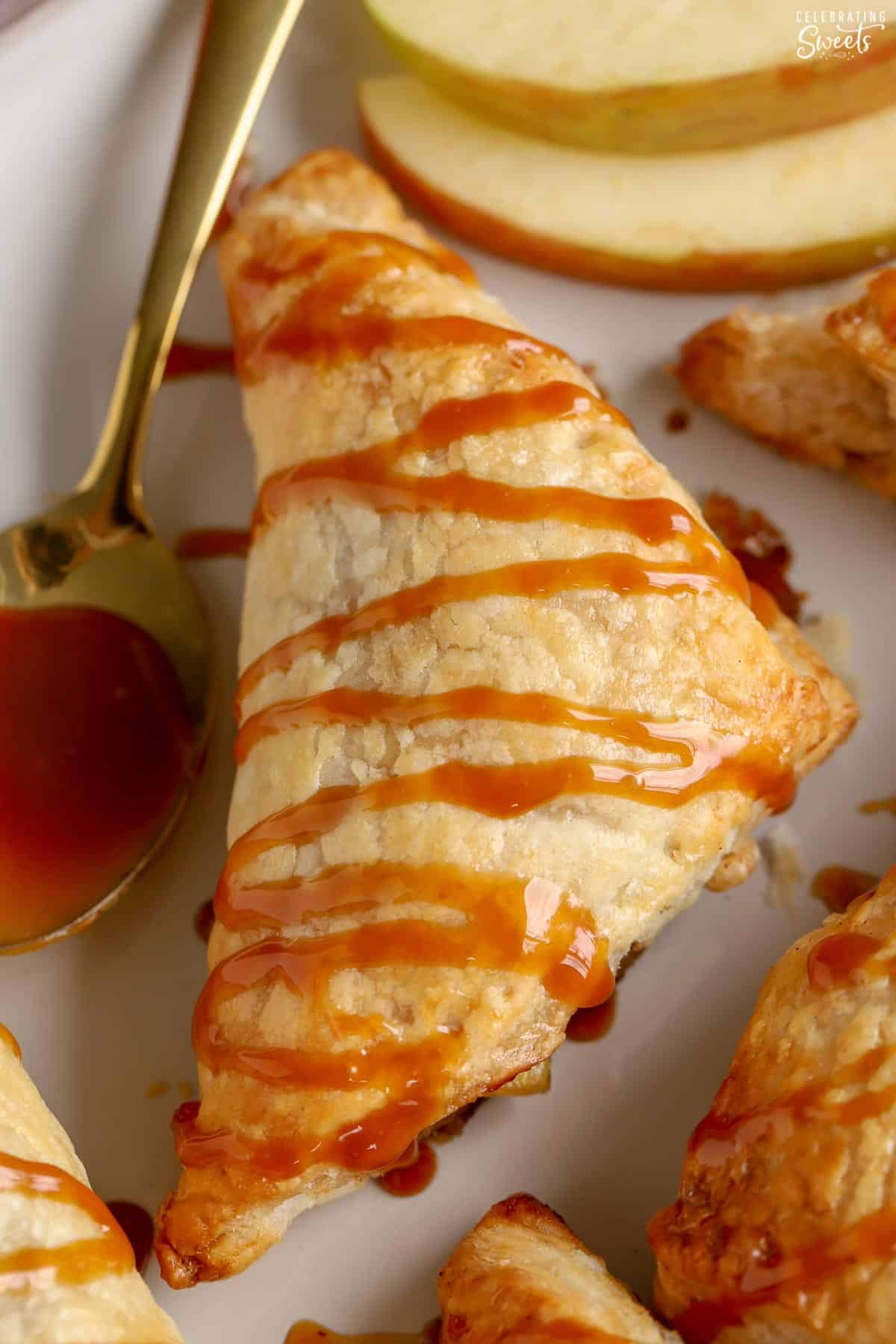 Closeup of an apple turnover drizzled with caramel sauce.