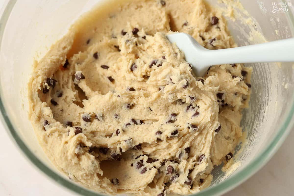 Chocolate chip cookie dough in a glass mixing bowl.