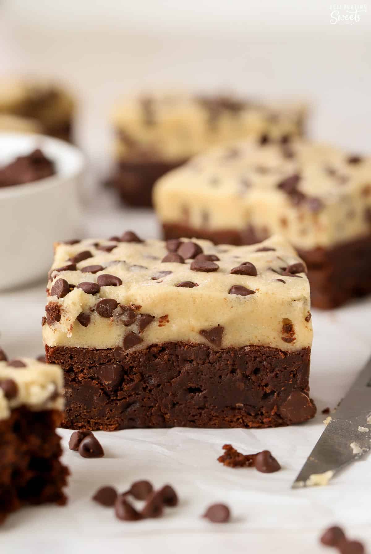 Closeup of a brownie topped with chocolate chip cookie dough.