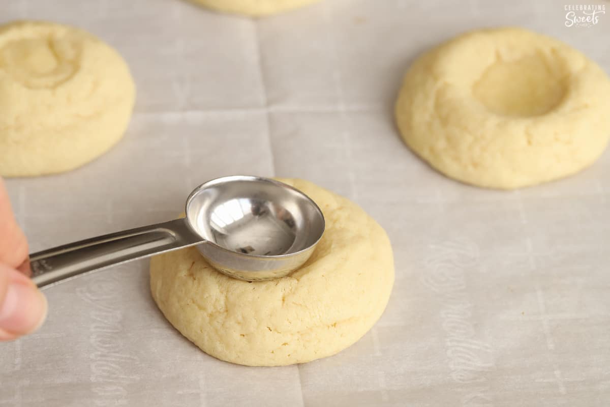 Tablespoon being pressed into a sugar cookie.