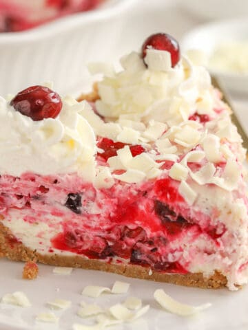 Slice of cranberry cheesecake on a white plate.