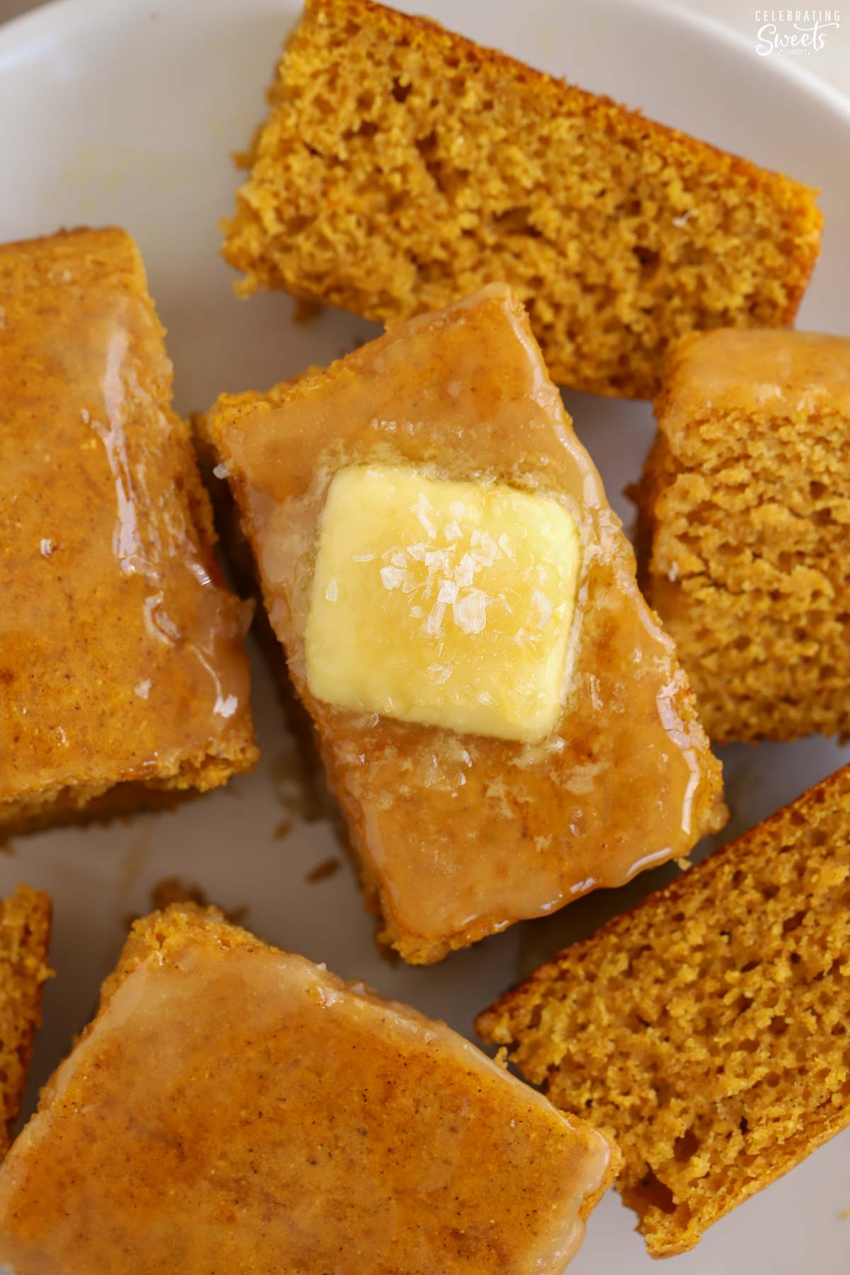 Slice of pumpkin cornbread topped with butter and honey.