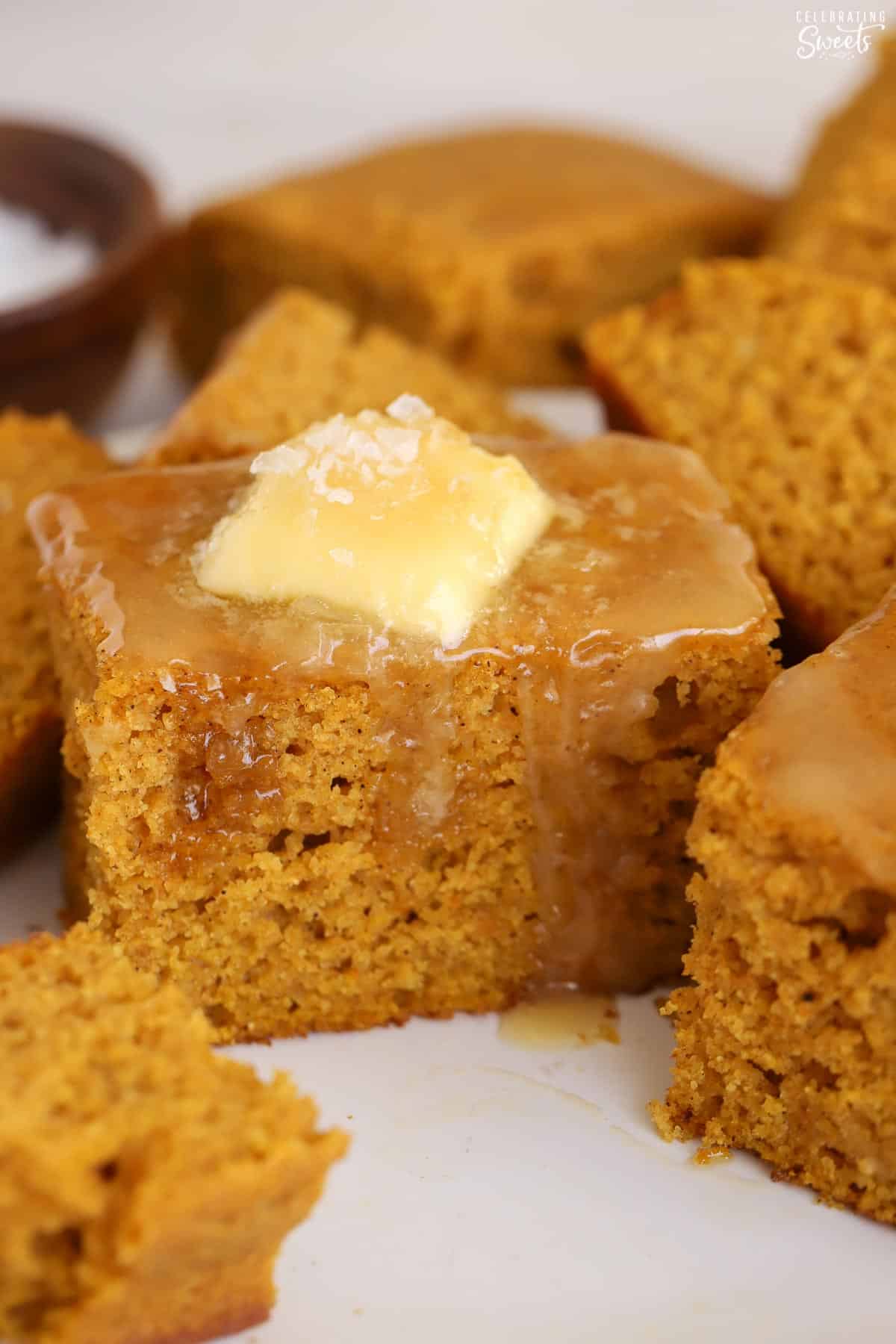 Slice of pumpkin cornbread topped with butter and honey.