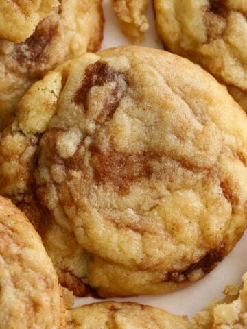 Closeup of cinnamon roll cookies on parchment paper.