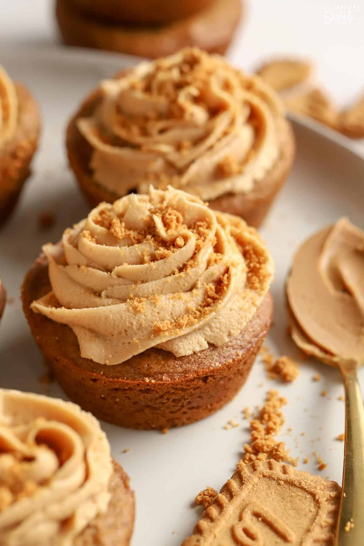 Gingerbread cookie cup topped with brown frosting on a white plate.