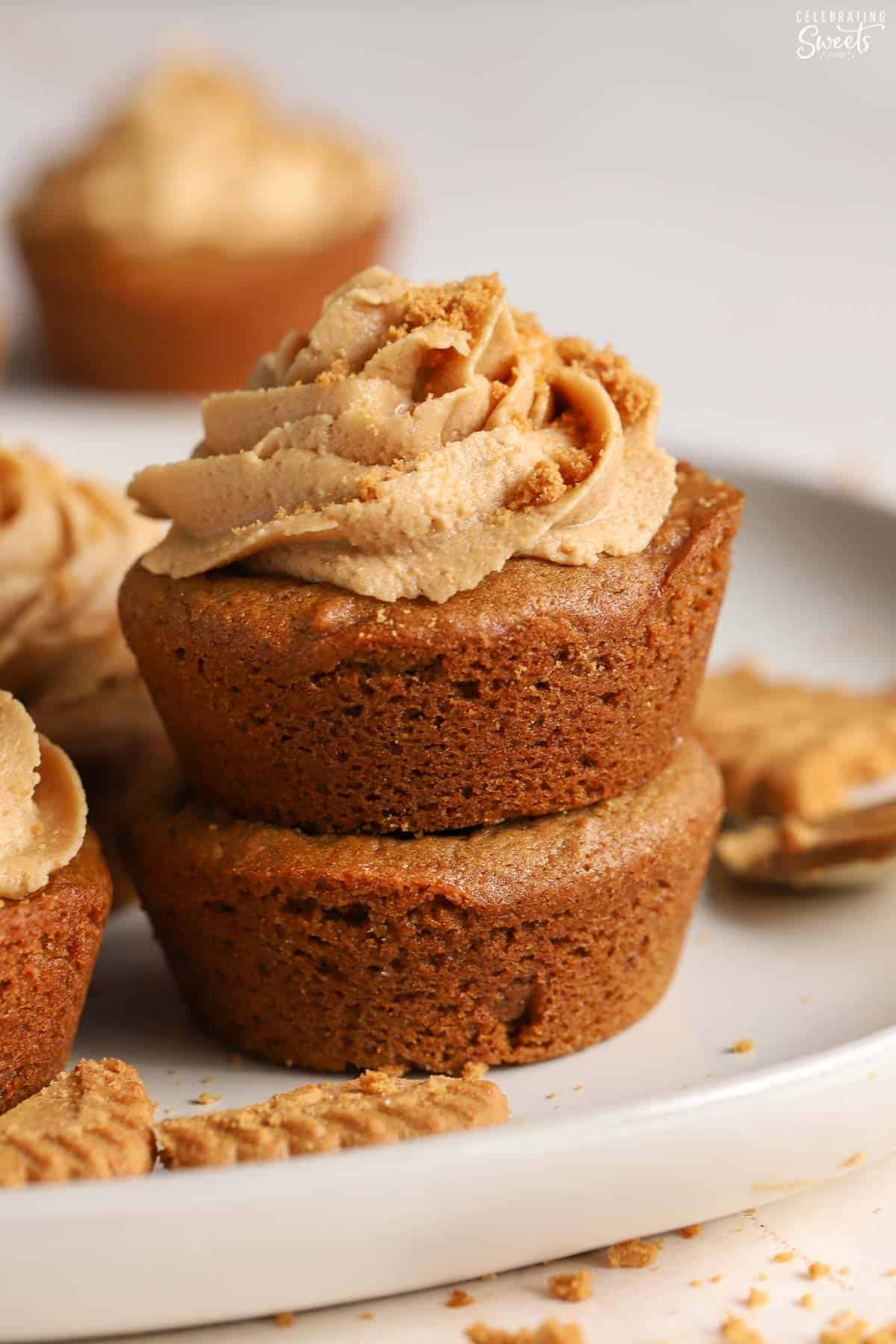 Stack of two gingerbread cookie cups with light brown frosting on top.