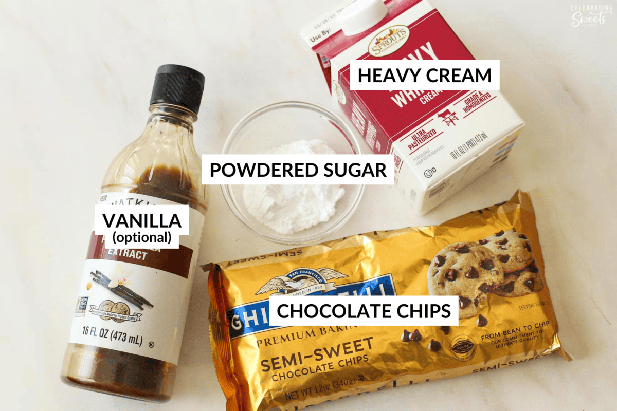 Ingredients for chocolate mousse: vanilla, powdered sugar in a glass bowl, a bag of chocolate chips, and a carton of heavy cream.