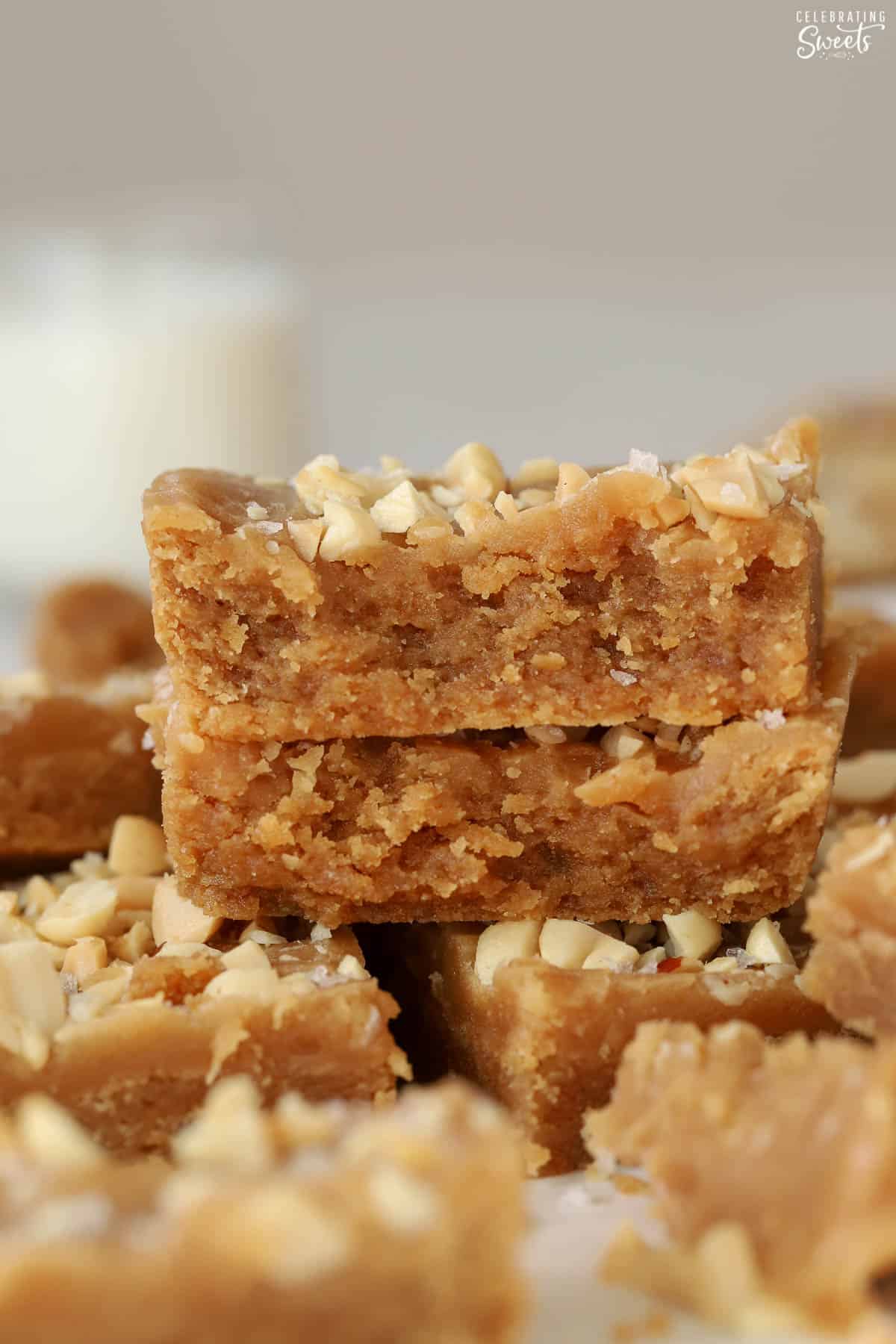 Stack of peanut butter bars topped with chopped peanuts.