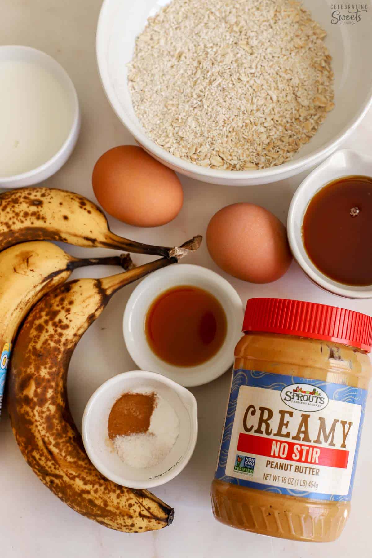Ingredients for banana oatmeal muffins (bananas, peanut butter, oats, baking powder, maple syrup, eggs, milk).