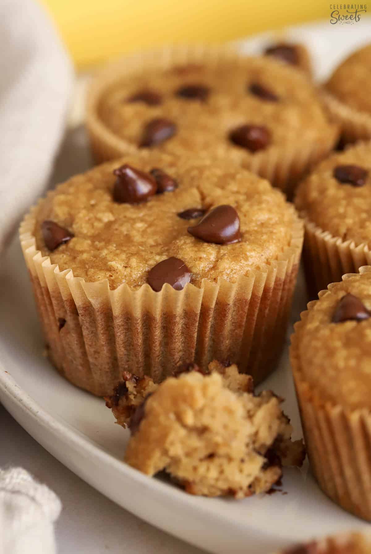 Banana oatmeal muffins topped with chocolate chips on a grey plate,