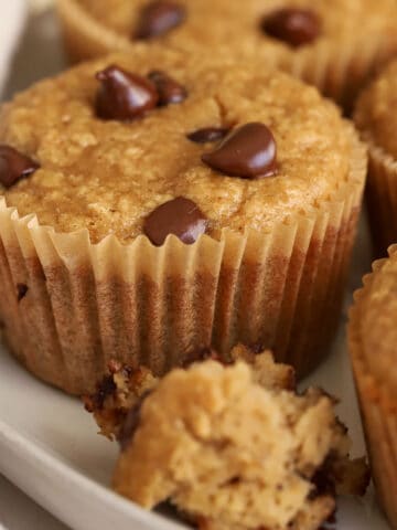 Banana oatmeal muffins topped with chocolate chips on a grey plate,