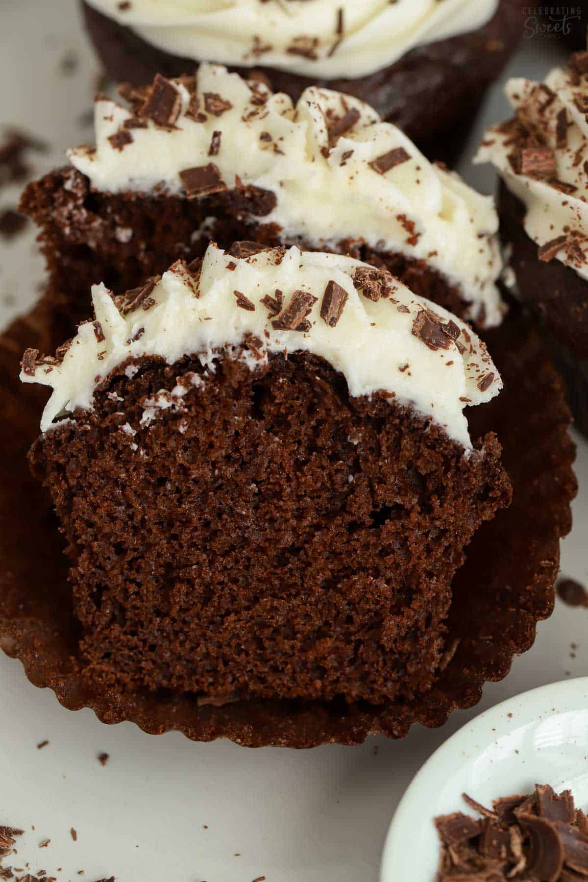 Chocolate cupcake cut in half on a white plate.