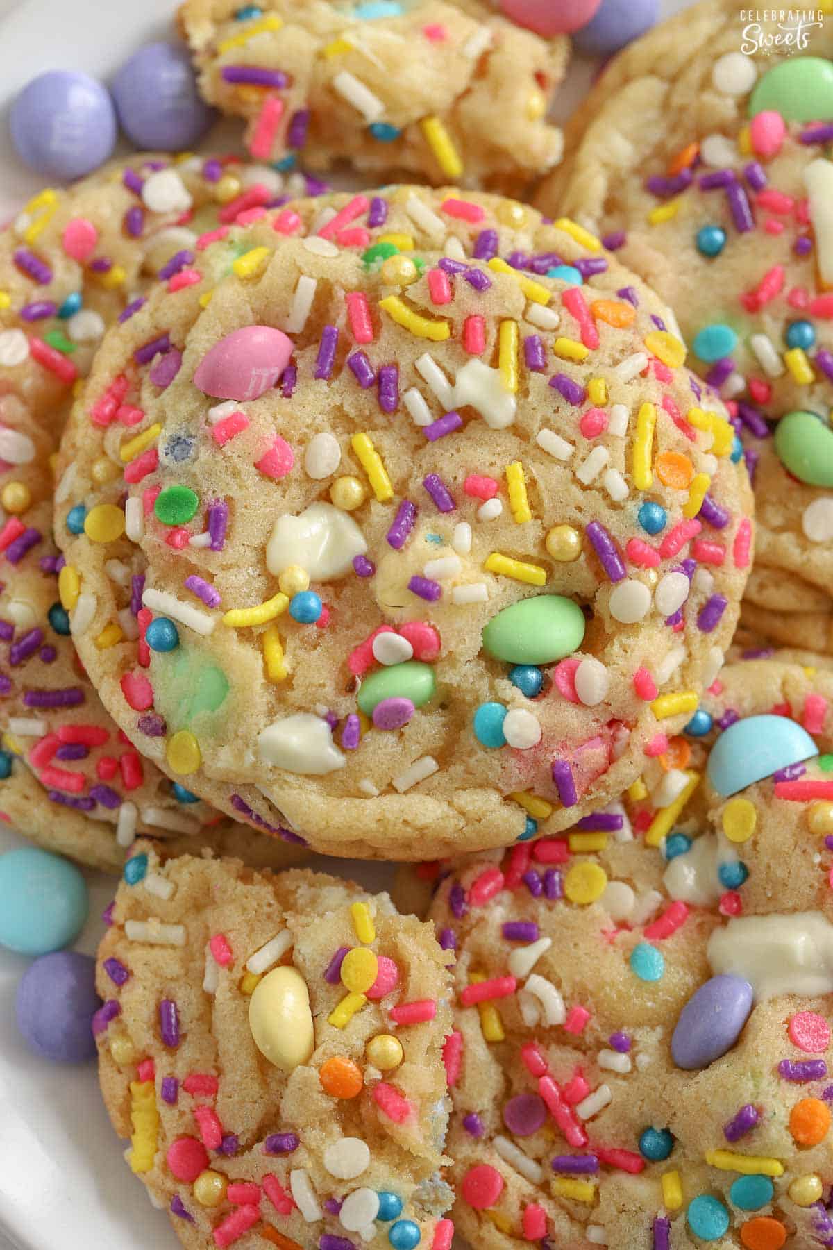 Closeup of cookies topped with pastel M&M's and sprinkles.