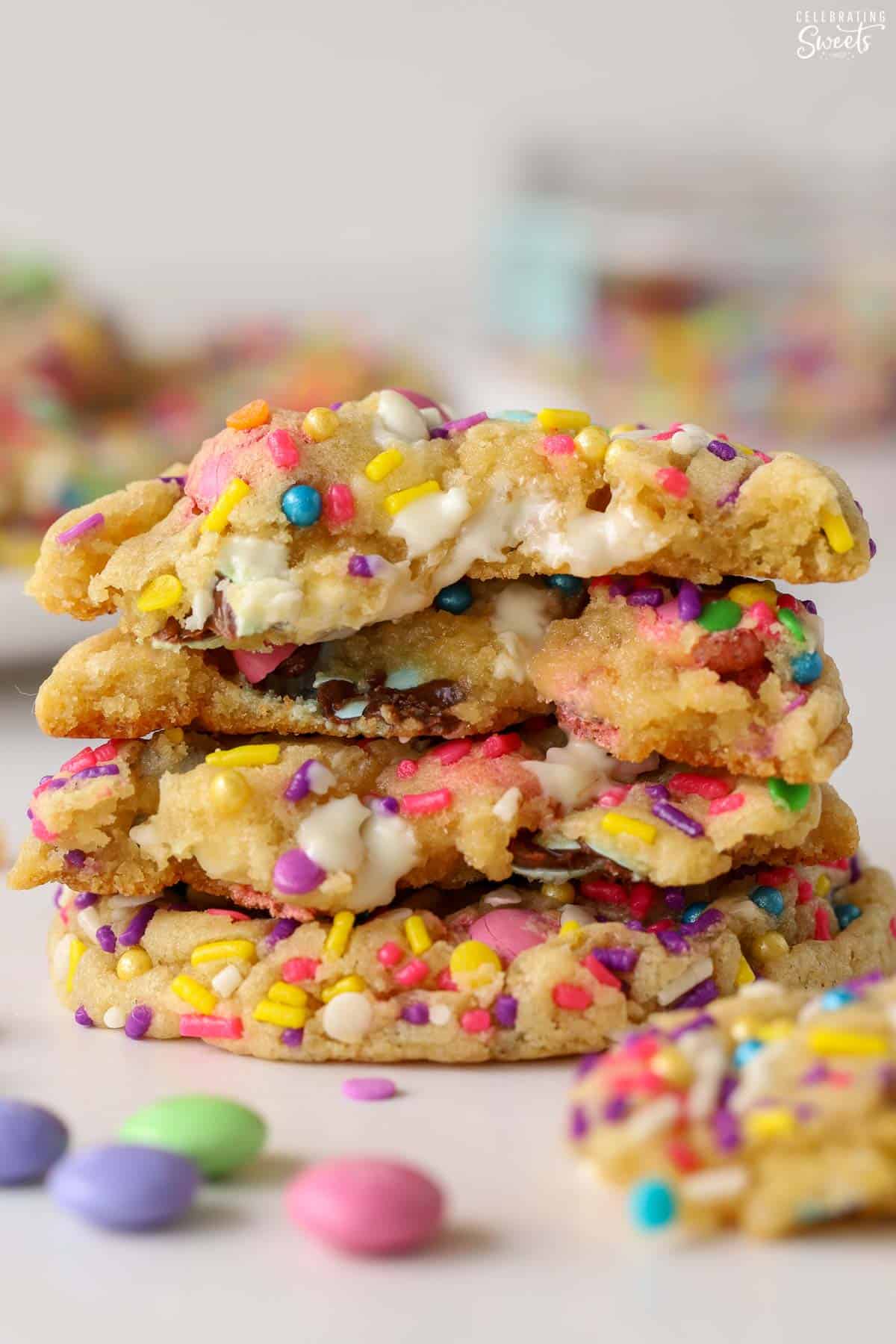 Stack of M&M cookies with white chocolate chips and pastel sprinkles.