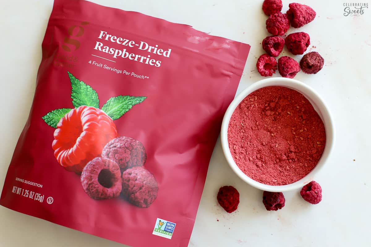 Freeze dried raspberries in a bag and in a white bowl.