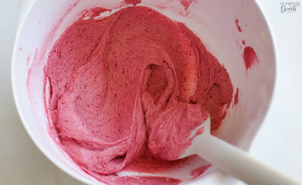 Raspberry frosting in a white bowl.