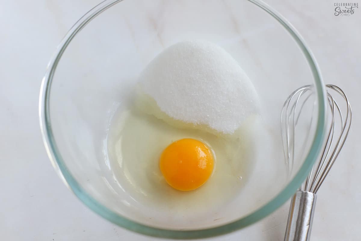 Egg and sugar in a glass bowl.
