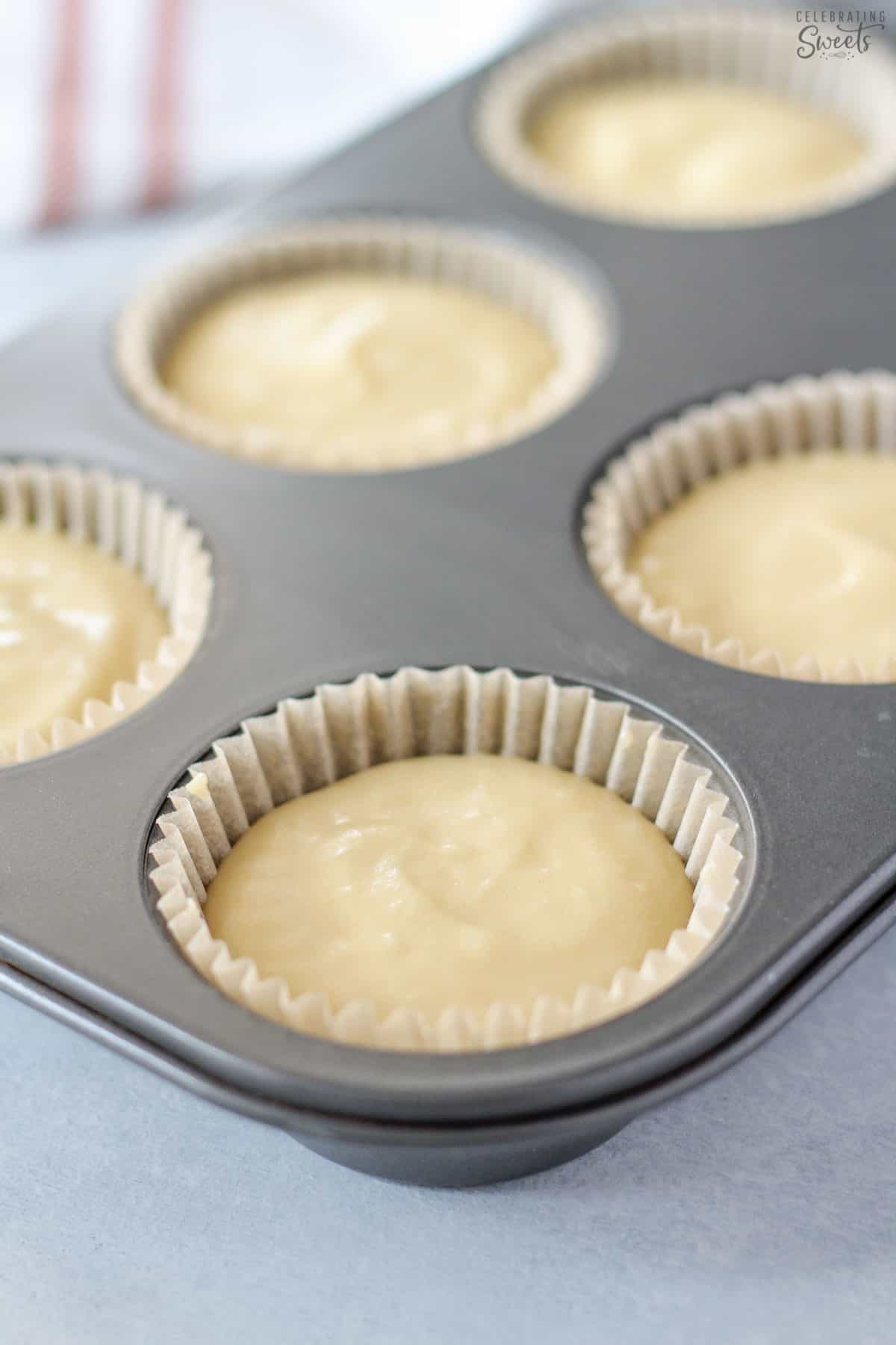 Vanilla cupcake batter in a muffin pan.