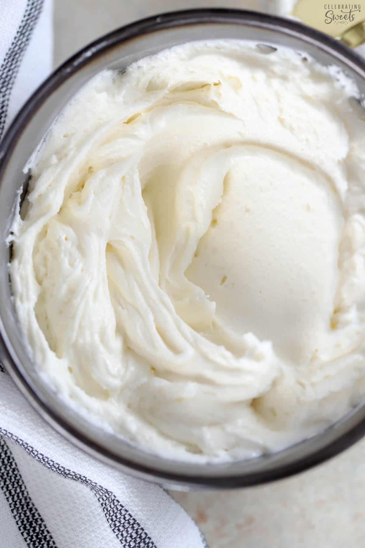 Vanilla buttercream frosting in a dark grey bowl.