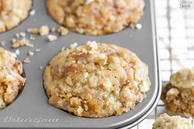 Banana nut muffin in a muffin pan on a wire rack.