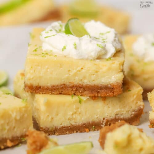 Stack of two key lime pie bars topped with whipped cream.