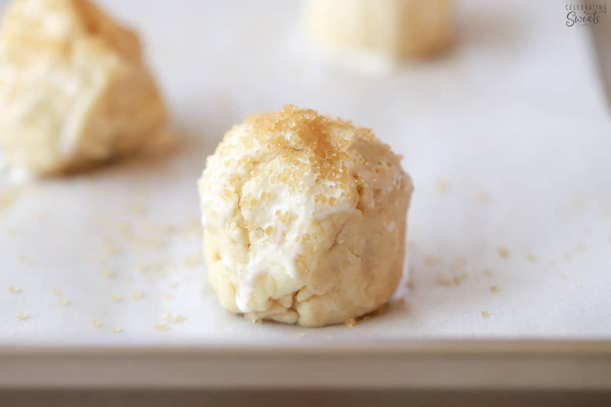 Unbaked shortcake biscuit on a baking sheet topped with raw sugar.