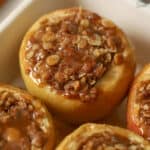 Baked apples topped with caramel in a baking dish.