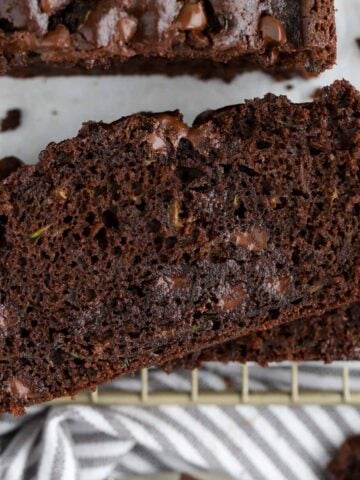 Slices of chocolate zucchini bread on a wire rack.