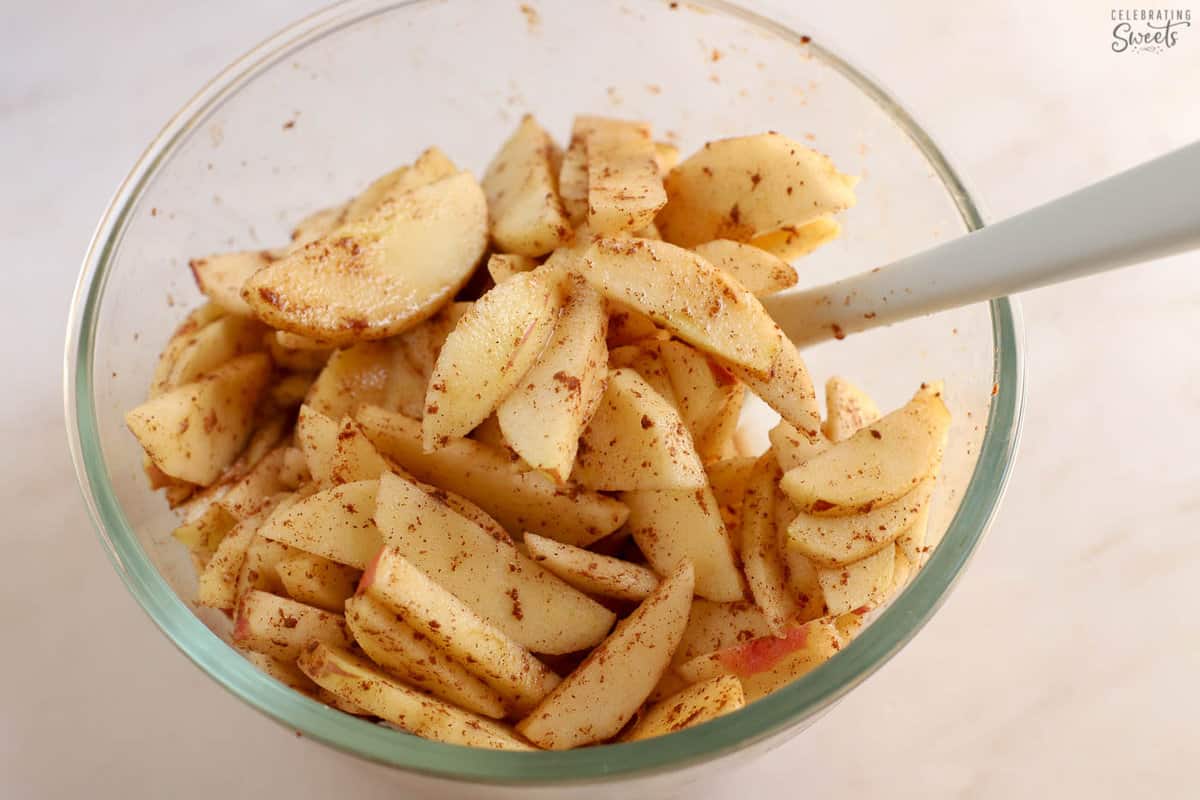 Sliced cinnamon apples in a glass bowl.