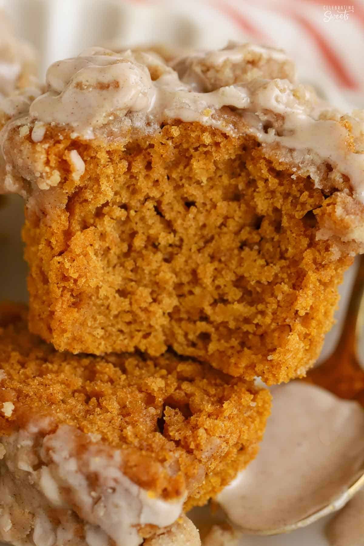 Pumpkin muffin with a bite taken out of it on a white plate.