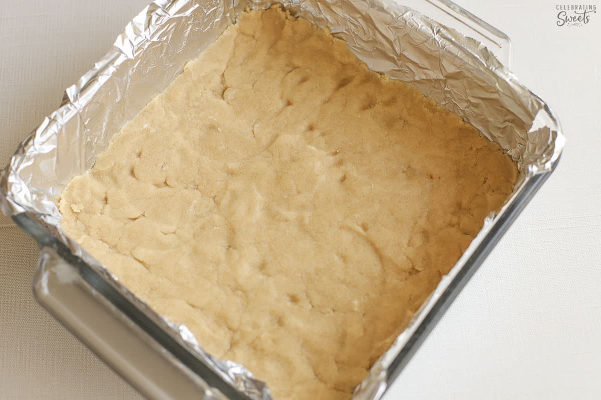 Unbaked shortbread crust in a foil-lined pan.