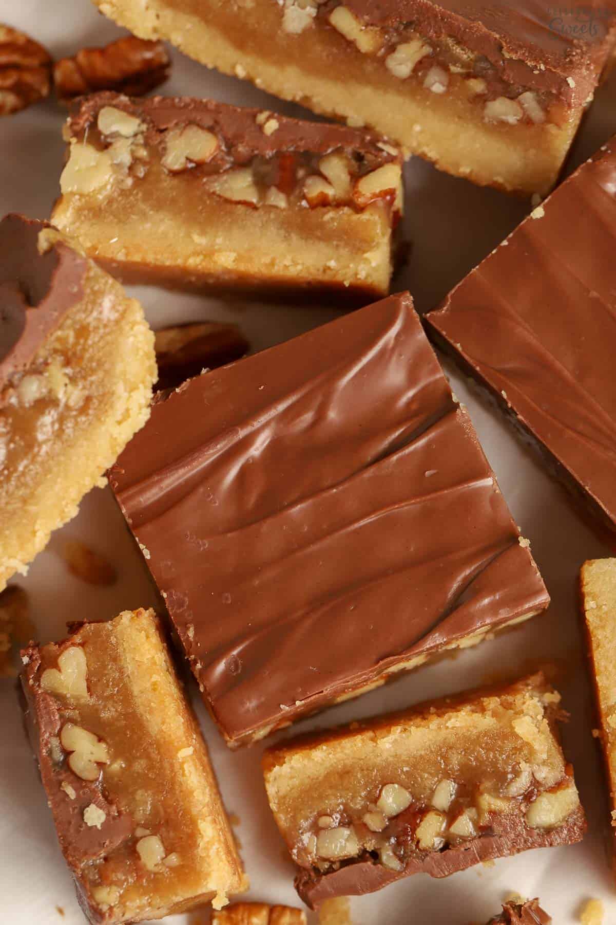 Chocolate caramel pecan bars on parchment paper.