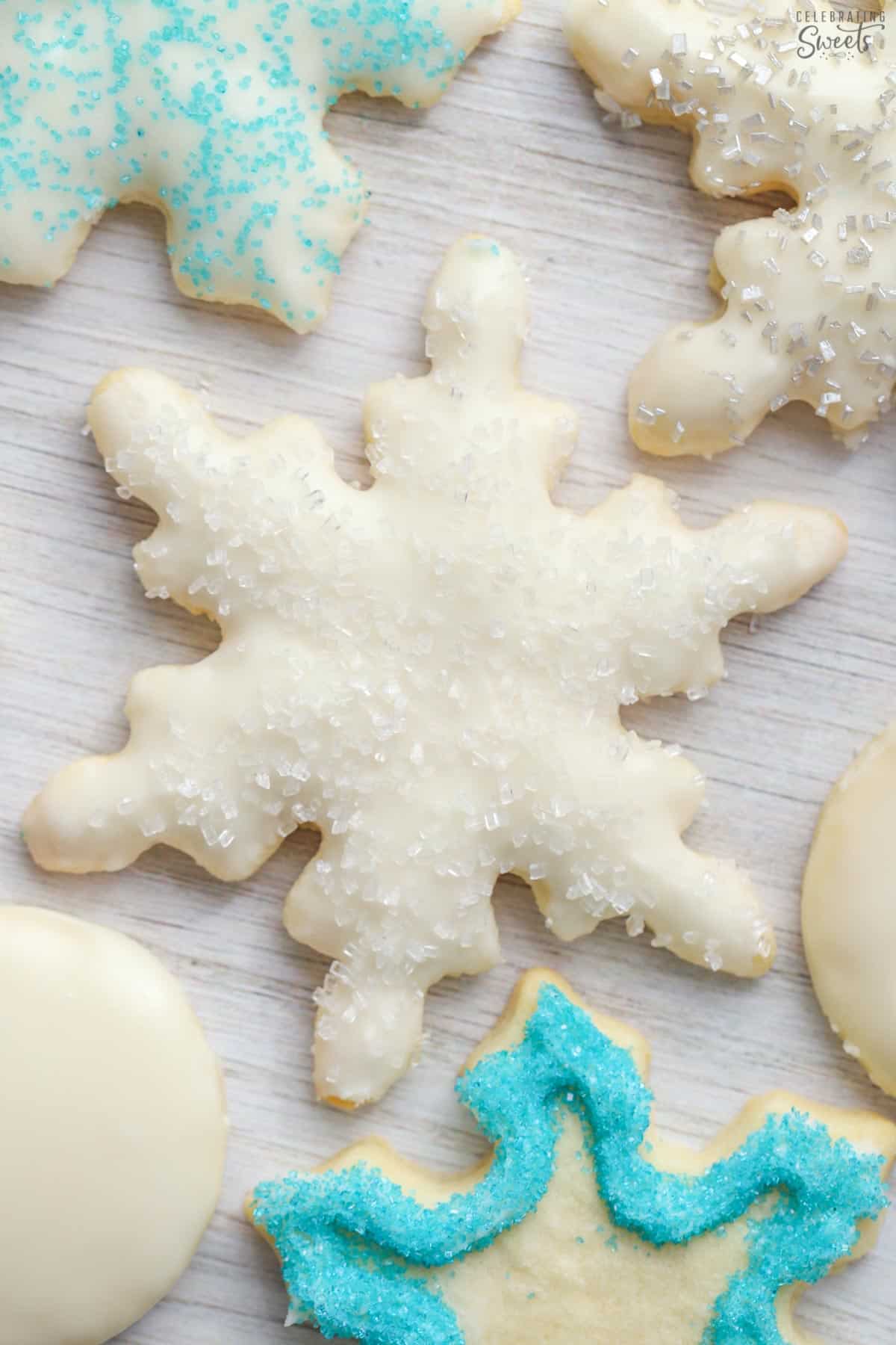 Frosted snowflake sugar cookies on a wood board.
