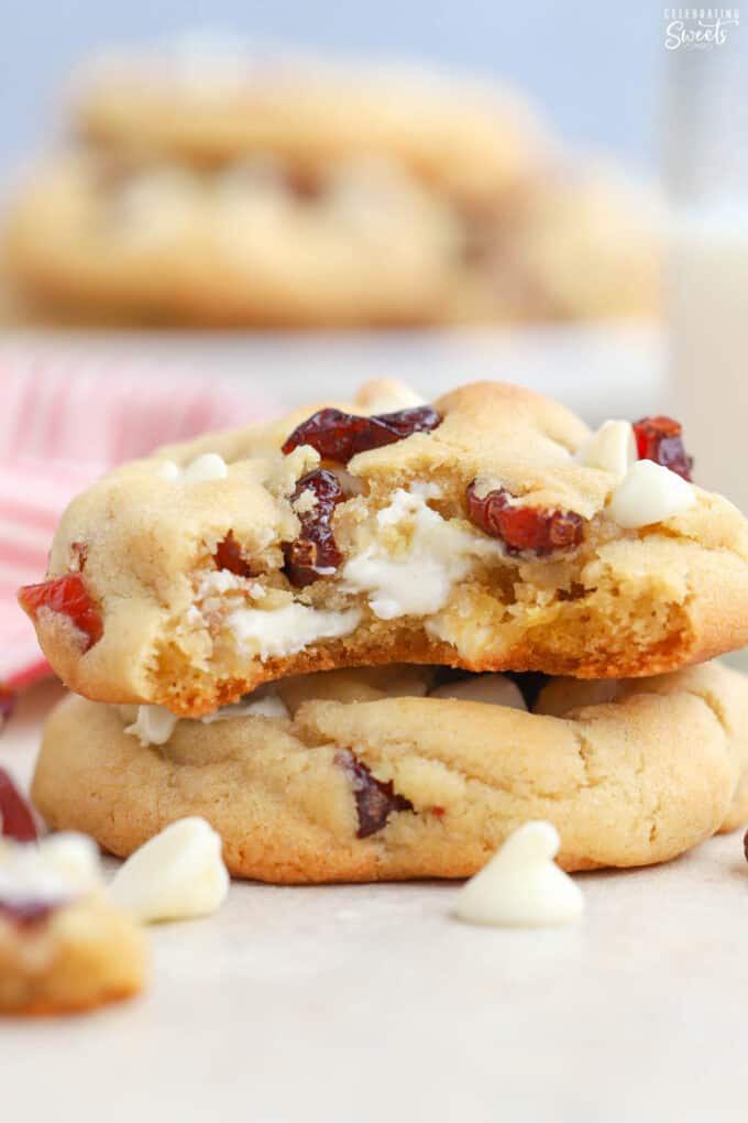 Stack of two white chocolate cranberry cookies with a bite taken out of the top cookie.