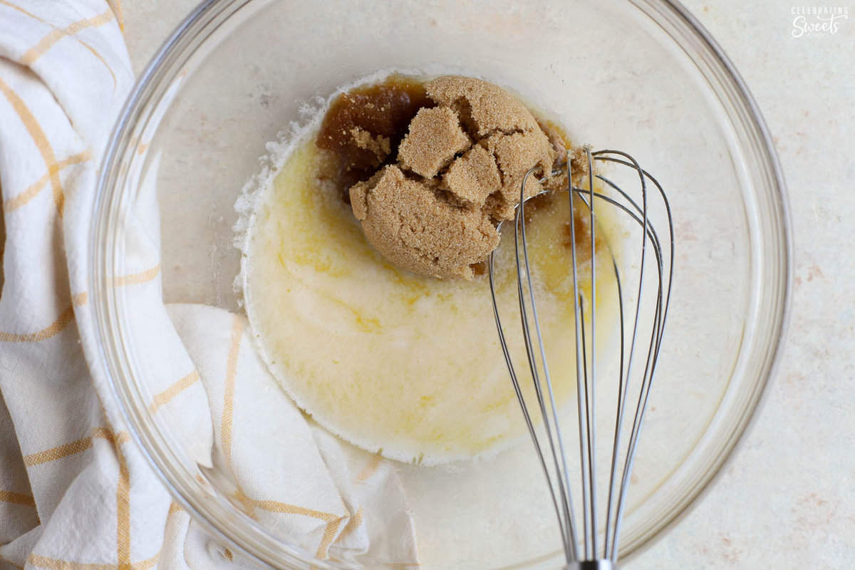 Melted butter and brown sugar in a glass bowl with a whisk.