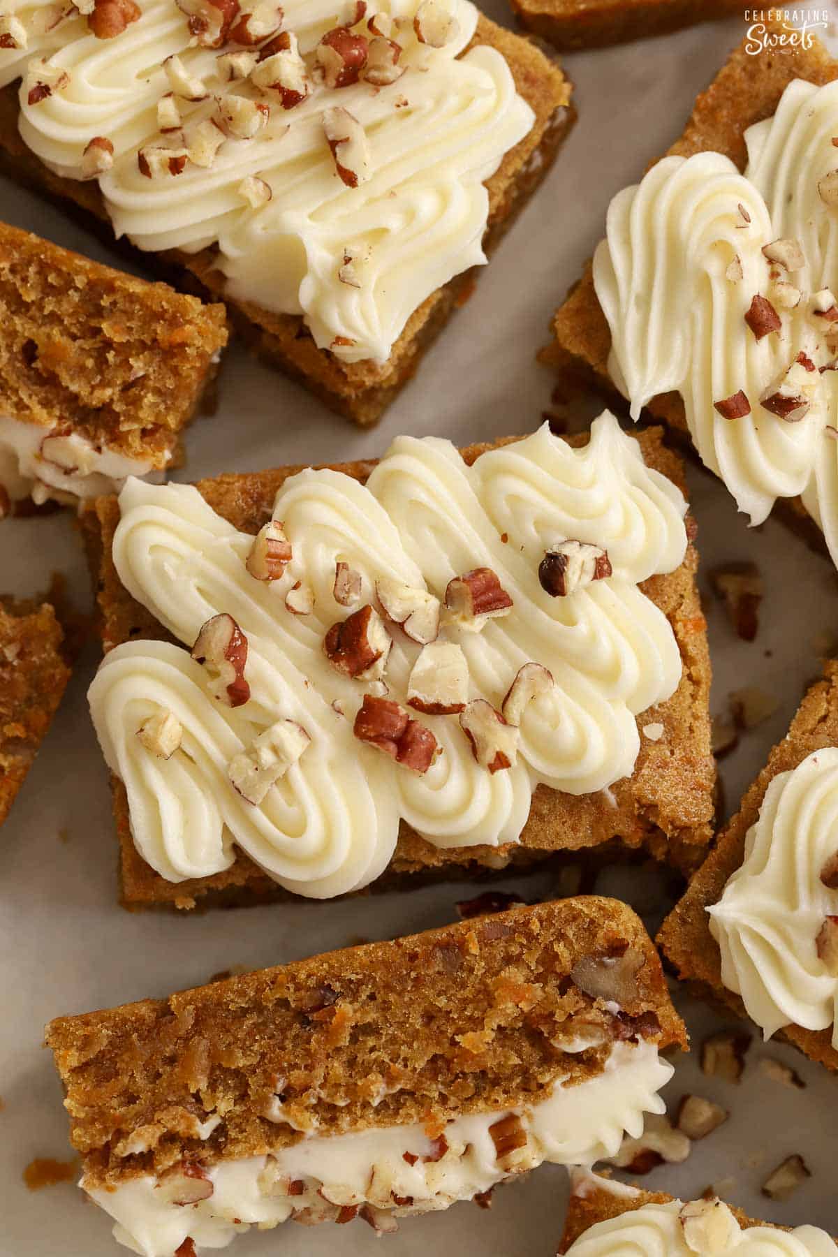 Overhead shot of carrot cake bars topped with frosting and pecans.