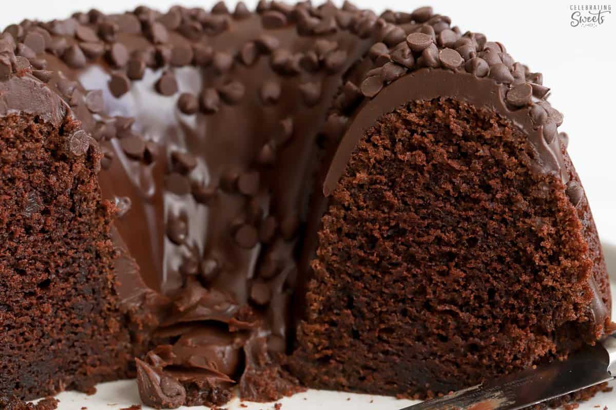 Closeup of a chocolate bundt cake topped with chocolate ganache and chocolate chips.